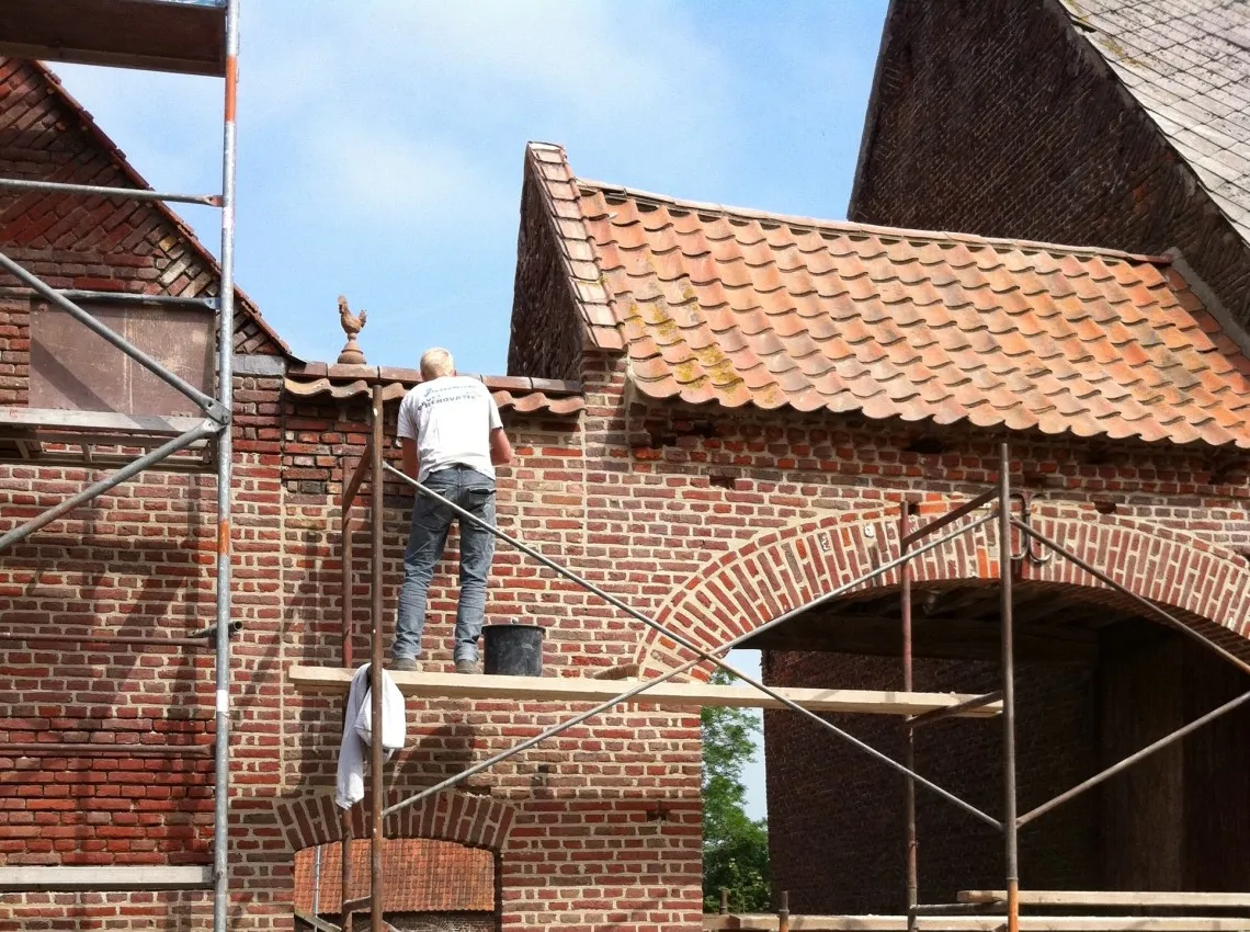 Gereinigde gevel van een boerderij na verwijderen van mos en aanslag, foto 1 van 6