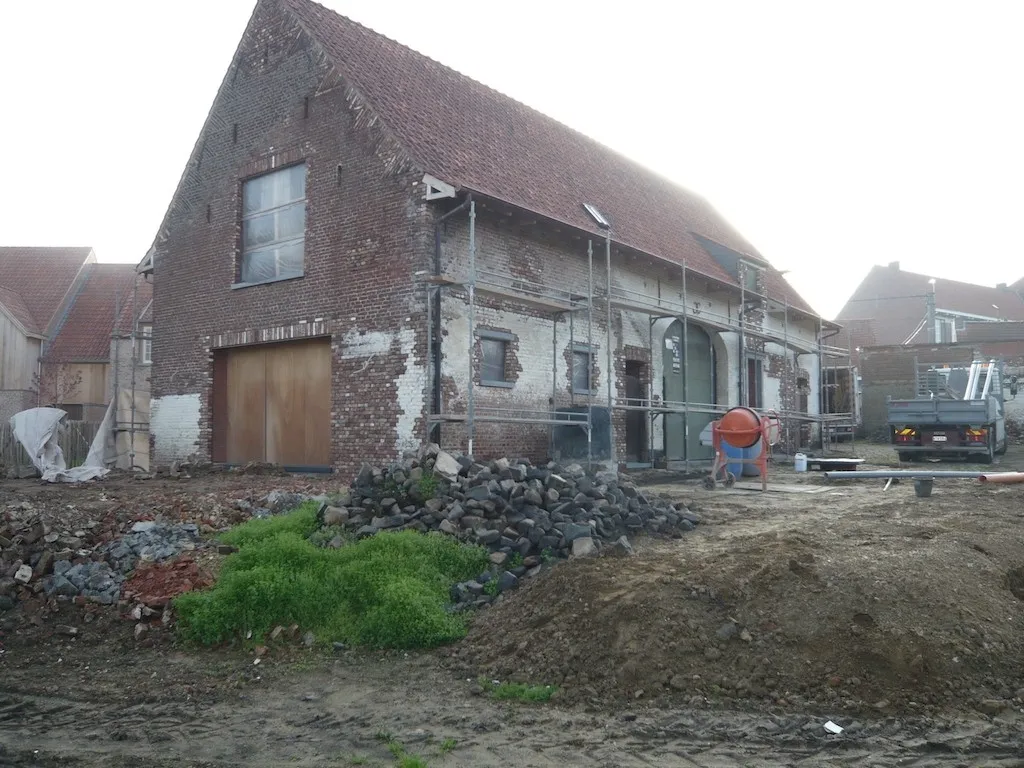 Gerenoveerde gevel van een hoeve met historisch metselwerk, foto 1 van 8