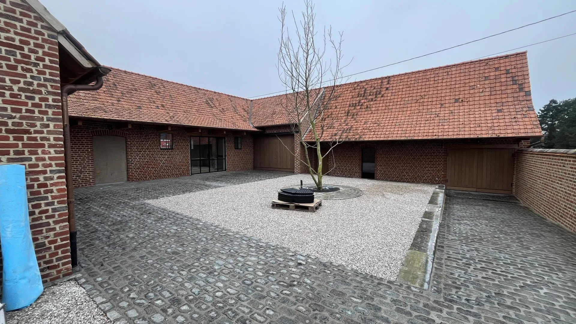 Binnenkoer van een gerenoveerde hoeve in Kooigem door Renovatie Jaumain