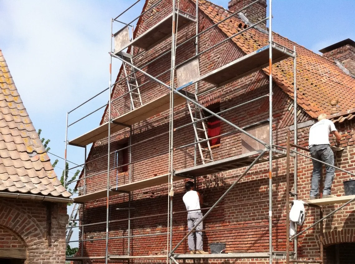 Gereinigde gevel van een boerderij na verwijderen van mos en aanslag, foto 2 van 6