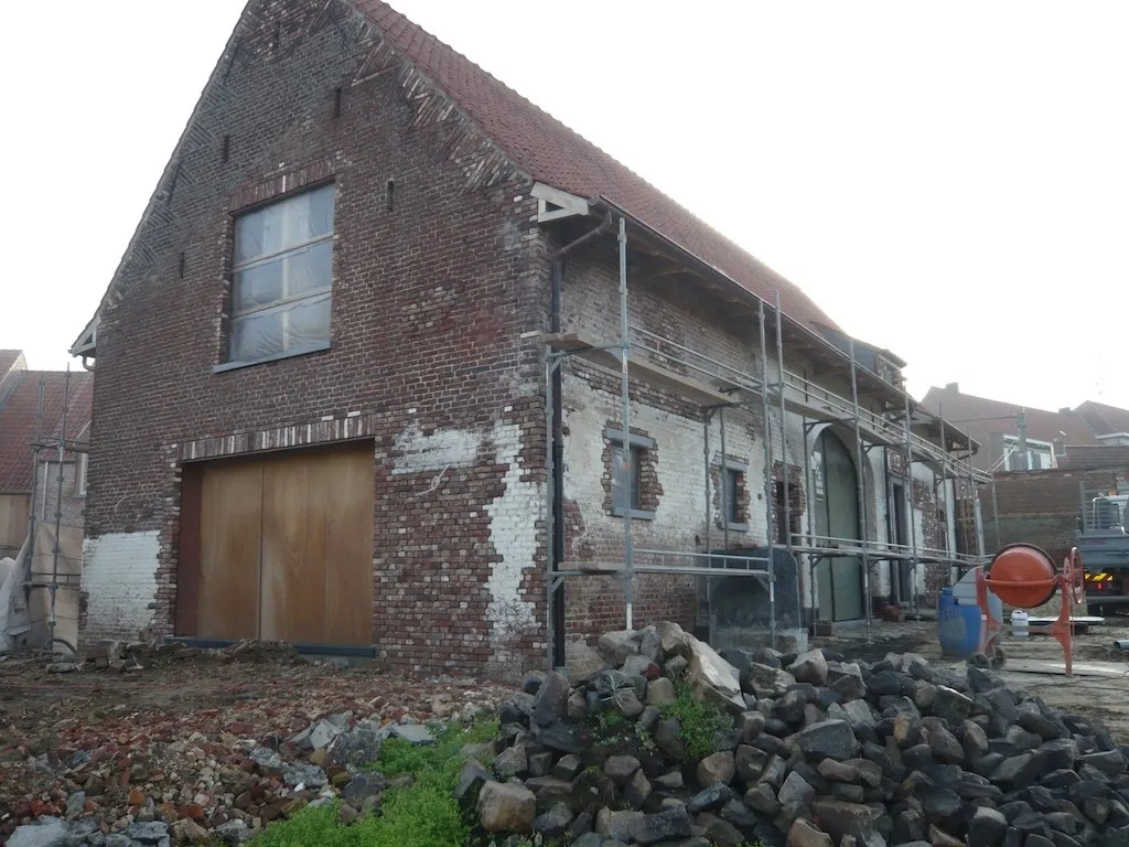 Gerenoveerde gevel van een hoeve met historisch metselwerk, foto 2 van 8