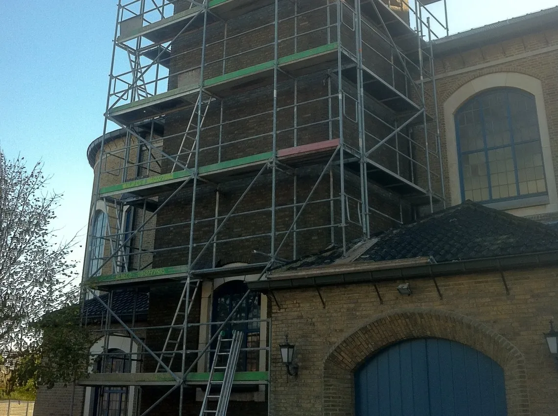Gereinigde en hervoegde kerktoren in historisch metselwerk, foto 2 van 3