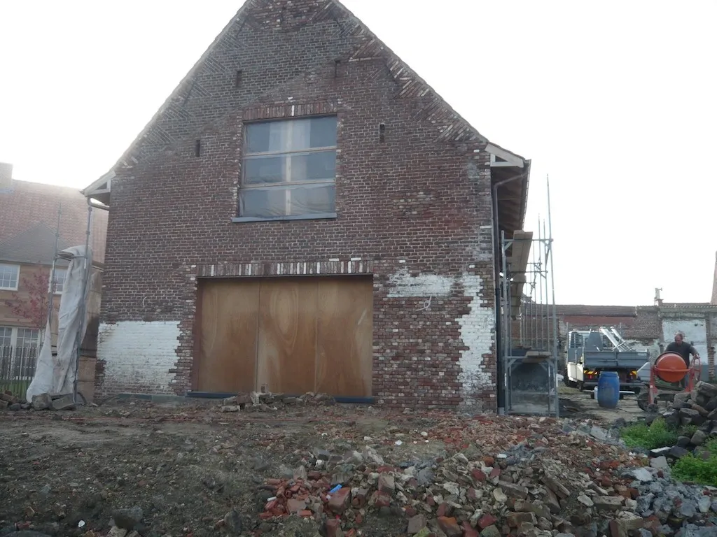 Gerenoveerde gevel van een hoeve met historisch metselwerk, foto 3 van 8