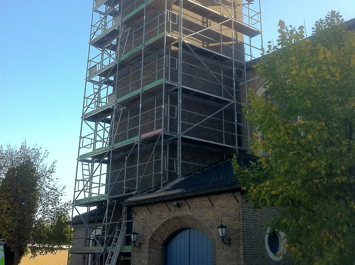 Gereinigde en hervoegde kerktoren in historisch metselwerk