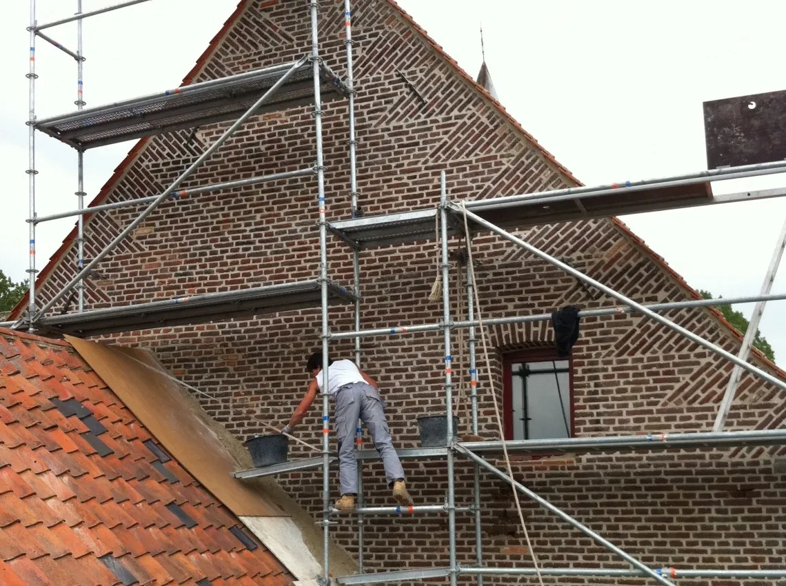 Gereinigde gevel van een boerderij na verwijderen van mos en aanslag, foto 5 van 6