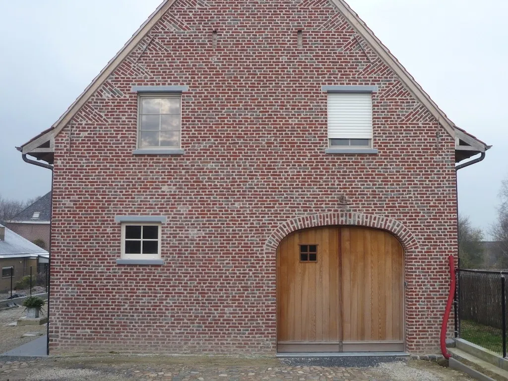 Gerenoveerde gevel van een hoeve met historisch metselwerk
