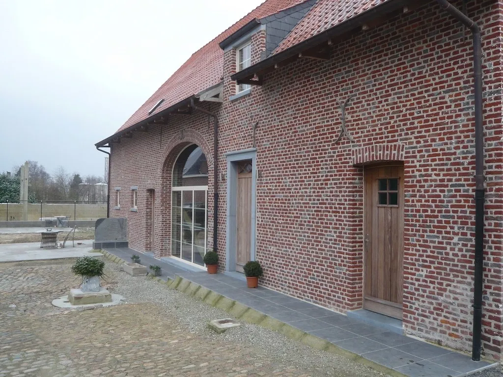 Gerenoveerde gevel van een hoeve met historisch metselwerk, foto 7 van 8